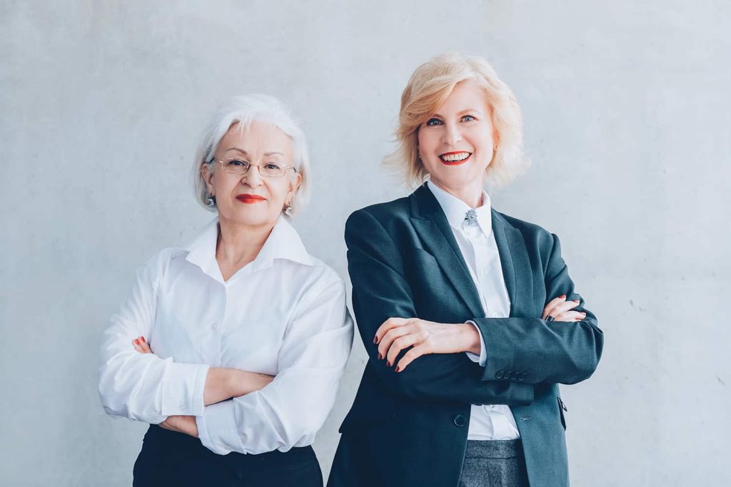 two-business-women-older-back-to-back