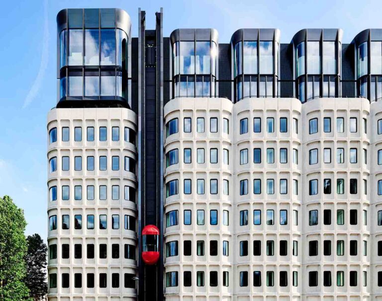 A modern hotel with a red lift on the outside
