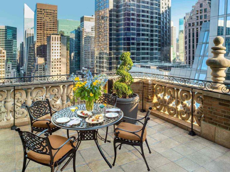 A roof terrace with a table laid with food and views of skycrapers